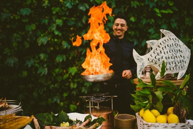 Chef prepara un piatto flambé durante l’aperitivo di matrimonio Villa Bossi Varese.
