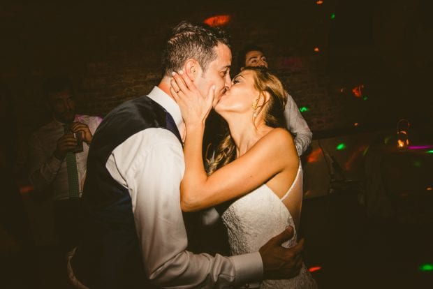 Gli sposi si scambiano un bacio romantico sulla pista da ballo durante il ricevimento a Villa Bossi.