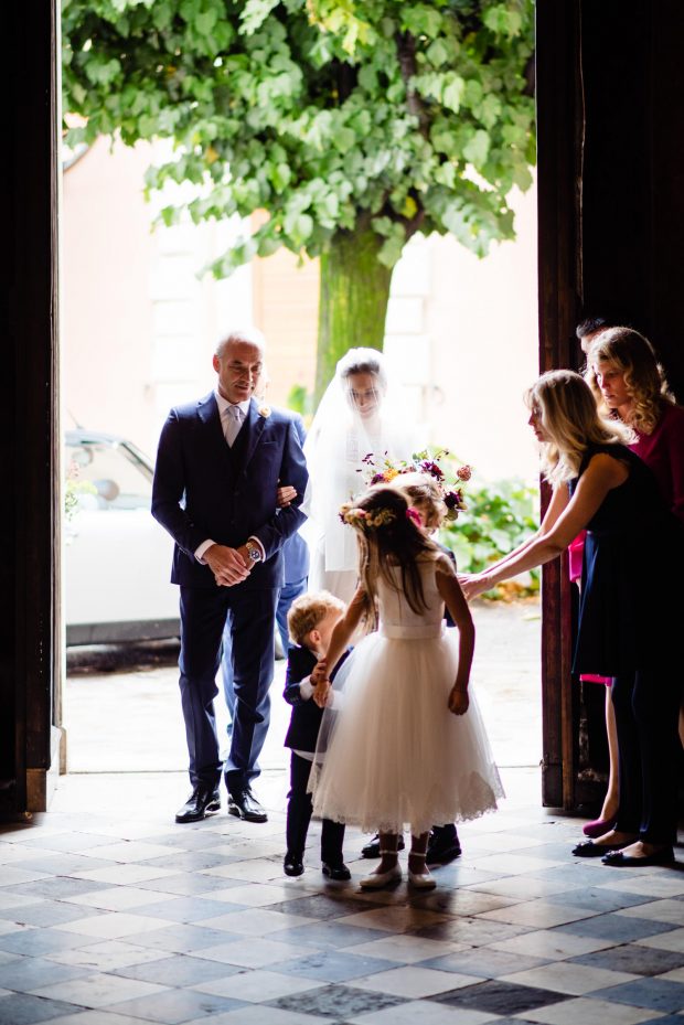 La sposa entra in chiesa con il padre, avvolta dall’emozione del momento durante il matrimonio a Villa Panza.
