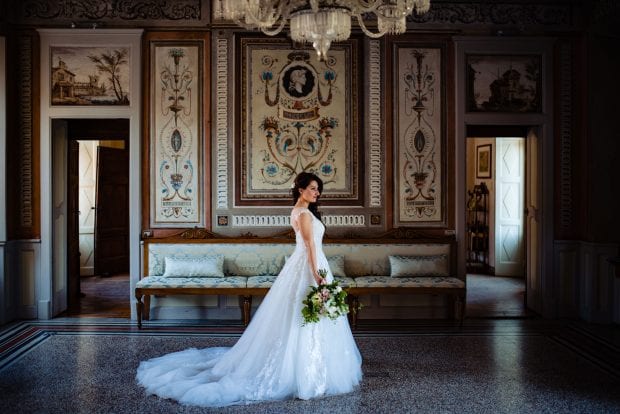 La sposa in posa in una sala affrescata di Villa Bossi prima della cerimonia, tra le Migliori Location Matrimonio Varese.