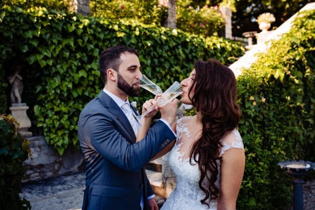 Gli sposi brindano felici con gli invitati durante il ricevimento a Villa Bossi.