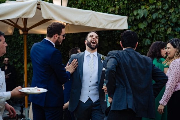 Lo sposo ride con gli amici durante il ricevimento di matrimonio a Villa Bossi.