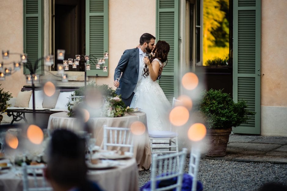 Gli sposi entrano al ricevimento a Villa Bossi e si scambiano un bacio tra gli applausi degli invitati