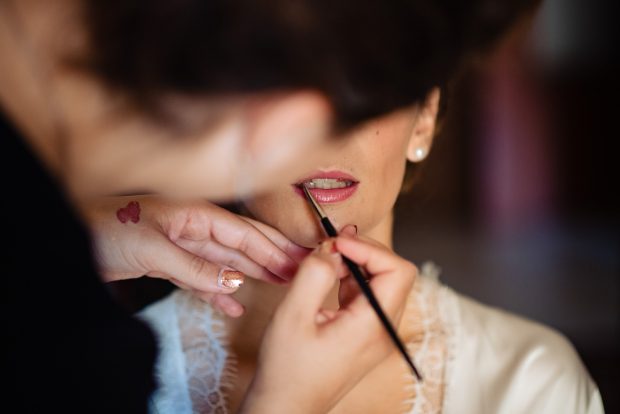 Primo piano delle labbra della sposa con rossetto nude per un look raffinato e senza tempo.