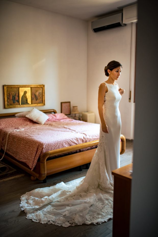 La sposa in abito bianco si osserva allo specchio con emozione e gioia nel giorno del suo matrimonio.