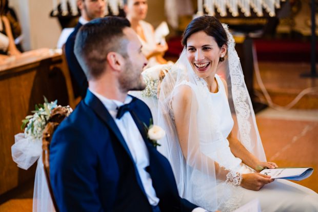 La sposa sorride felice all’altare, colma di gioia e amore nel suo giorno speciale.