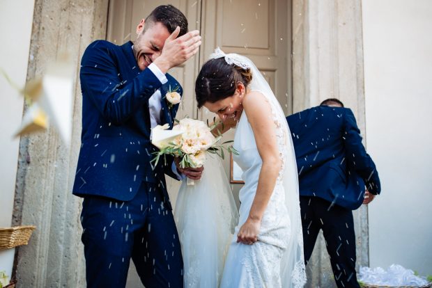 Gli sposi escono dalla chiesa avvolti in una pioggia di riso lanciato dagli invitati in festa.
