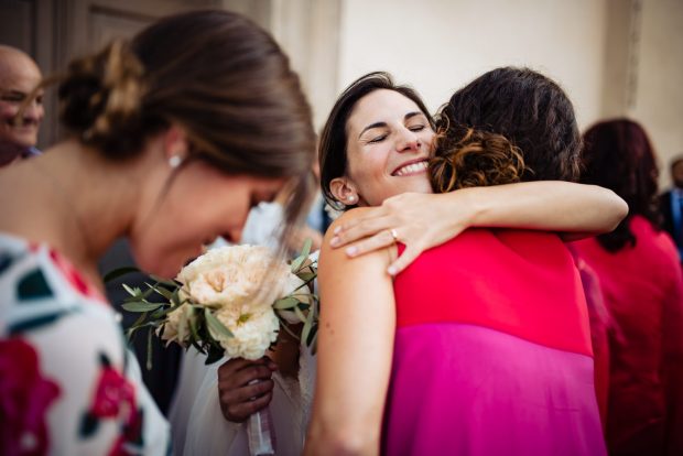 La sposa abbraccia calorosamente un’invitata, un momento di affetto e commozione.