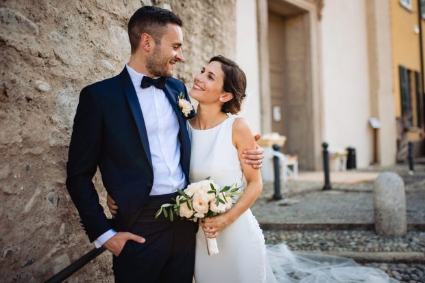 Gli sposi si stringono in un abbraccio emozionante appena usciti dalla chiesa, circondati dagli invitati.