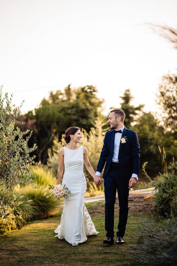 Gli sposi camminano mano nella mano nel parco di Tenuta Serradesca, immersi nella natura e nella loro felicità.
