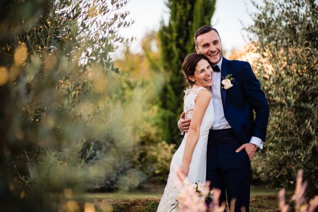 Gli sposi si stringono in un abbraccio sorridente, celebrando il loro amore a Tenuta Serradesca.
