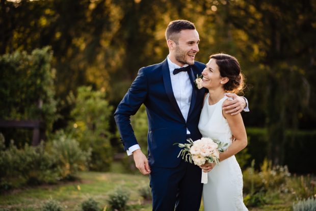 Gli sposi sorridono dolcemente mentre il sole tramonta su Tenuta Serradesca, creando un’atmosfera romantica.