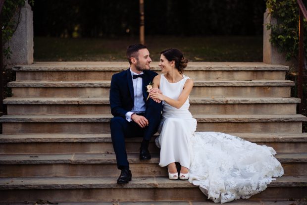Gli sposi si siedono sulle scale di Tenuta Serradesca, condividendo un momento di intimità e complicità.