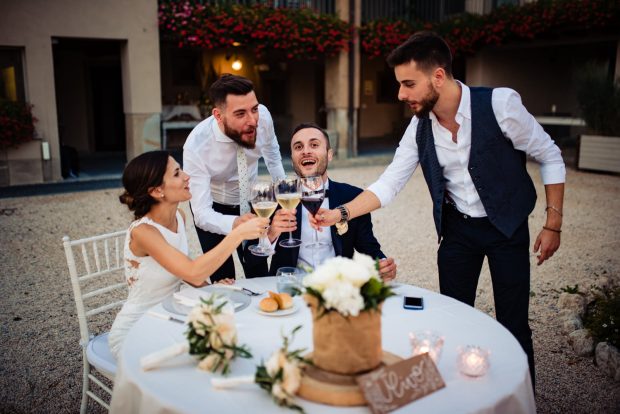 Gli amici degli sposi alzano i calici per un brindisi speciale, celebrando l’amore e la felicità della coppia.