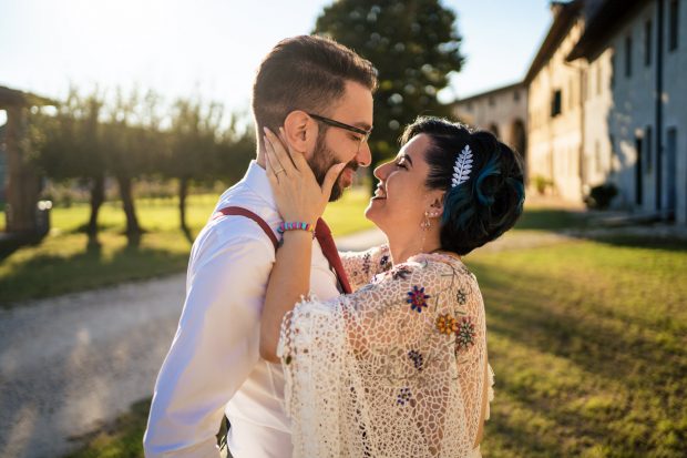 Veronica e Stefano si abbracciano al tramonto, immersi in una luce calda e romantica che esalta il loro amore.