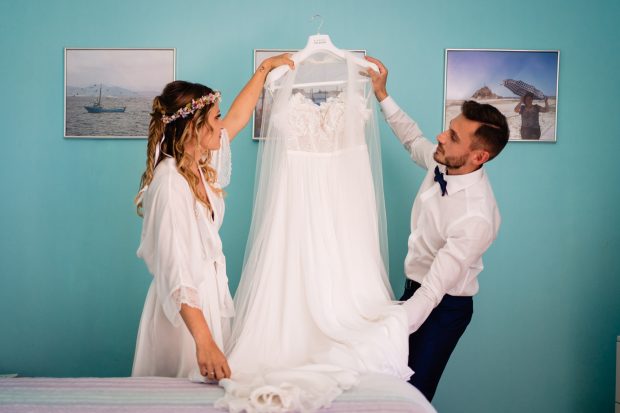 Sposa e fratello emozionati mentre preparano l’abito per il matrimonio a Villa Calchi.