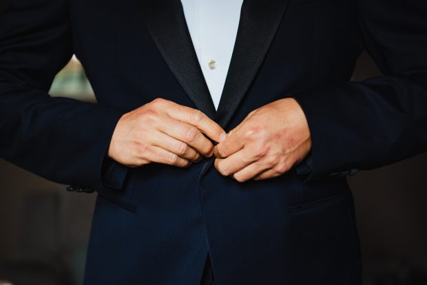 Lo sposo sistema la giacca prima della cerimonia, un dettaglio elegante del servizio fotografico a Villa Calchi.