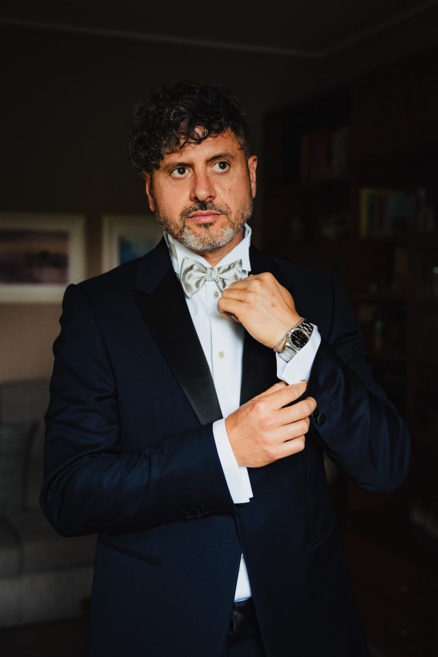 Lo sposo regola il suo orologio da polso, un dettaglio raffinato nel reportage fotografico a Villa Calchi.