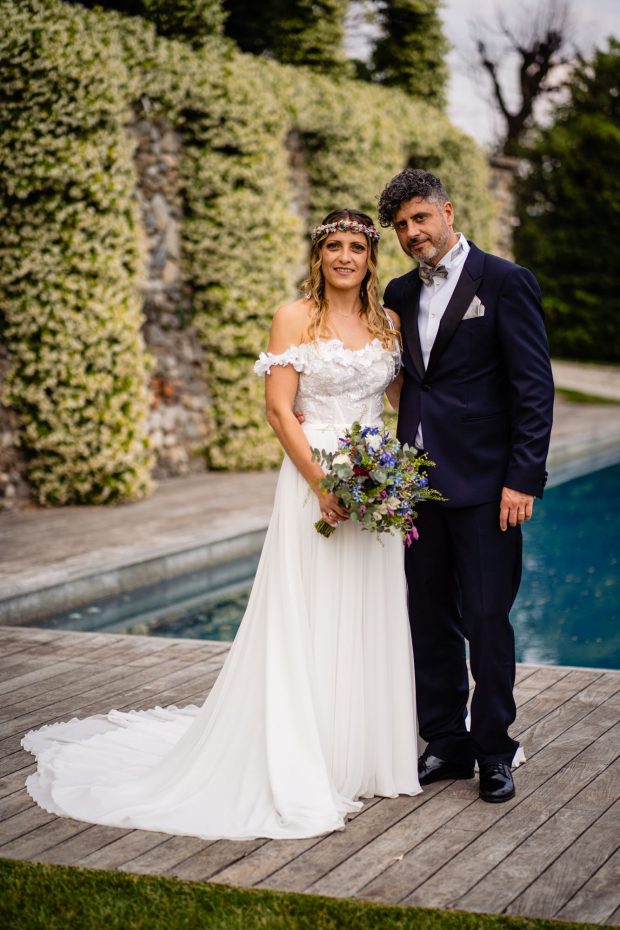 Gli sposi posano con eleganza di fronte alla piscina di Villa Calchi, in uno scatto da reportage di matrimonio. Fotografo matrimonio Varese Villa Calchi.