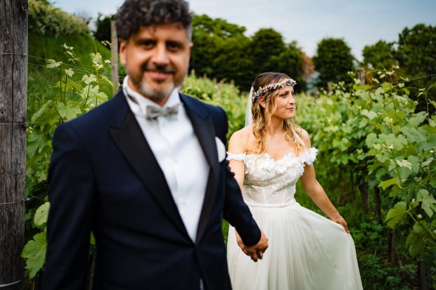 Lo sposo stringe la mano della sposa con dolcezza, un’immagine simbolica del loro legame. Fotografo matrimonio Varese Villa Calchi.