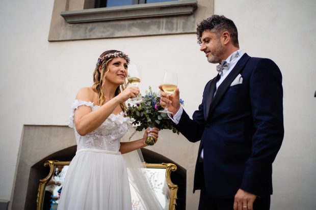 Gli sposi brindano felici all’aperitivo, un momento di gioia nel matrimonio a Villa Calchi. Fotografo matrimonio Varese Villa Calchi.