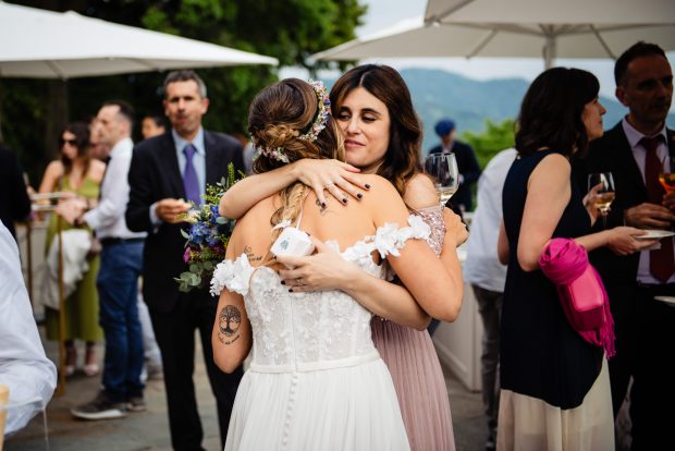 Un abbraccio emozionante tra la sposa e la sua testimone durante l’aperitivo a Villa Calchi. Fotografo matrimonio Varese Villa Calchi.
