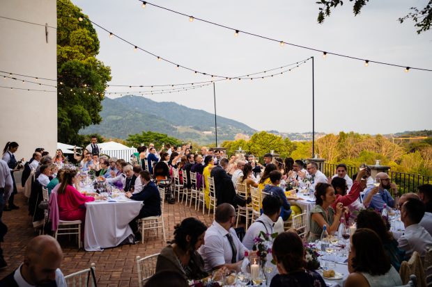 Vista ampia della terrazza di Villa Calchi con tavoli elegantemente allestiti e invitati in festa. Fotografo matrimonio Varese Villa Calchi.