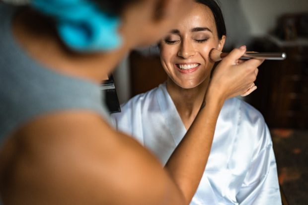 Sposa che sorride mentre viene truccata, fotografata a Villa Antona Traversi.