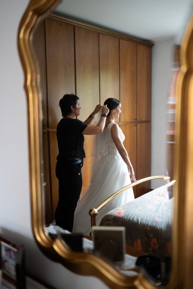 Parrucchiera che posa il velo sulla sposa, fotografato da un fotografo matrimonio Villa Antona Traversi.