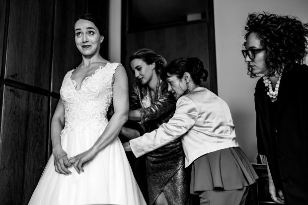 Testimone della sposa che chiude l'abito a Villa Antona Traversi.