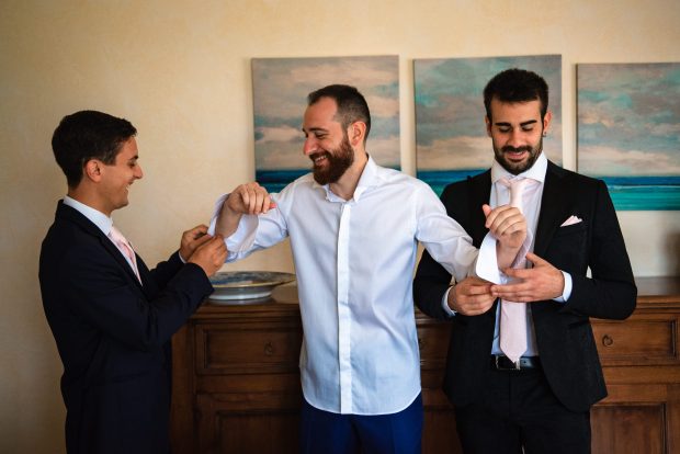 Lo sposo sistema con eleganza i gemelli del polsino, catturato da un fotografo matrimonio Villa Antona Traversi.