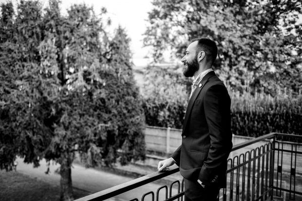 Lo sposo osserva fuori dalla finestra, pensieroso e pronto per il matrimonio a Villa Antona Traversi.