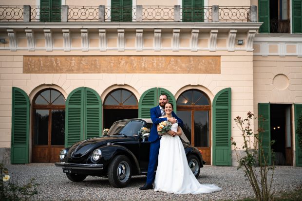 Un ritratto elegante degli sposi davanti alla loro auto, un dettaglio unico catturato nella suggestiva location di Villa Antona Traversi.
