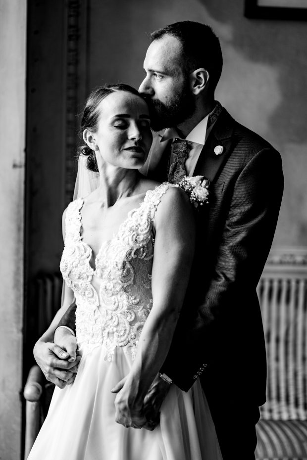 Dettaglio degli sposi illuminati dalla luce naturale alla finestra a Villa Antona Traversi.