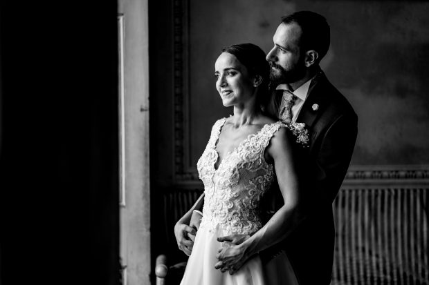 Gli sposi posano davanti alla finestra con luce naturale a Villa Antona Traversi.