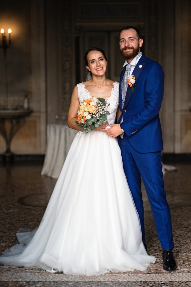 Gli sposi posano sorridenti con il bouquet durante il matrimonio a Villa Antona Traversi.