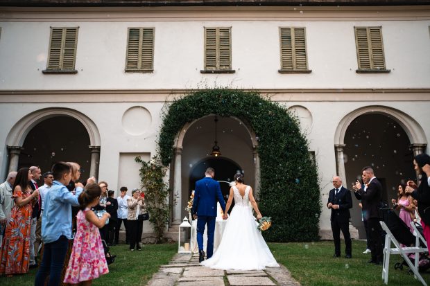 Gli sposi camminano verso la torta nuziale durante il ricevimento a Villa Antona Traversi.