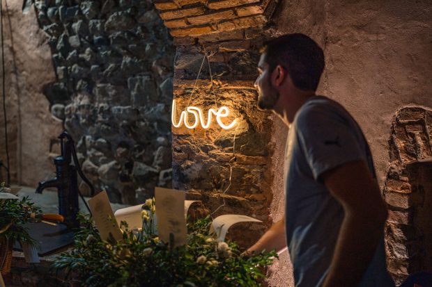 David, lo sposo, mentre accende il cartello luminoso con la scritta LOVE