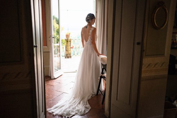 Patrizia che indossa il suo abito da sposa con l'aiuto delle amiche. Scatto realizzata da Paolo Lamperti Photographer Fotografo matrimonio Varese e Tenuta Frizzoni.