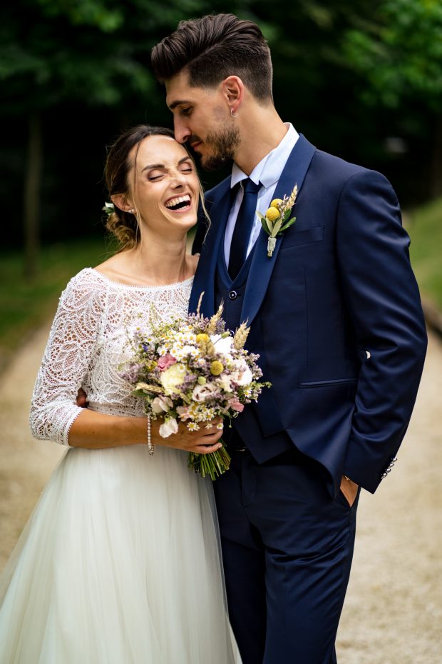 "Ritratto intimo: sposa che ride e sposo che la bacia sulla fronte – fotografo matrimonio Mulino dell’Olio