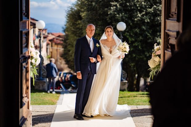 La sposa a braccetto con il padre all’ingresso della chiesa, fotografo matrimonio Varese Villa Claudia