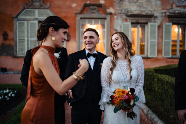 Sposi e amici ridono insieme davanti a Villa Malliana da Paolo Lamperti