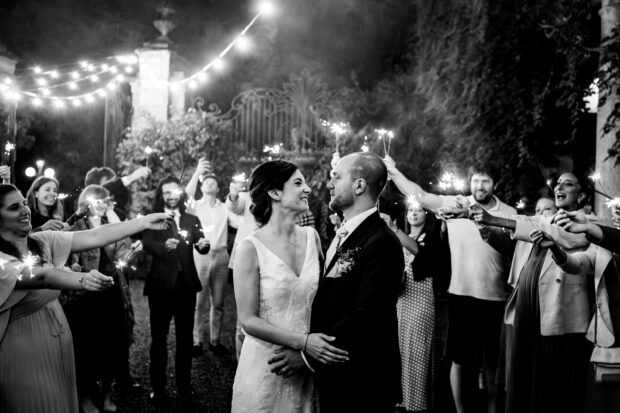Gli sposi camminano tra le scintille accese dagli amici per una foto suggestiva