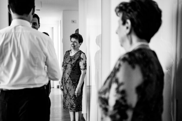 La mamma dello sposo osserva con divertimento i preparativi del figlio prima del matrimonio a Villa Gaia Gandini.