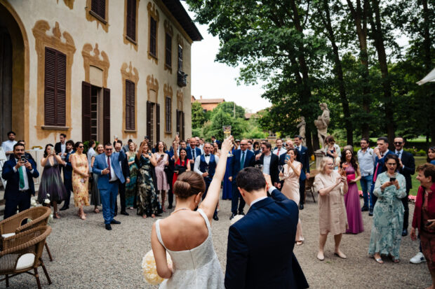 Gli sposi brindano mentre gli invitati applaudono durante il matrimonio a Villa Gaia Gandini.