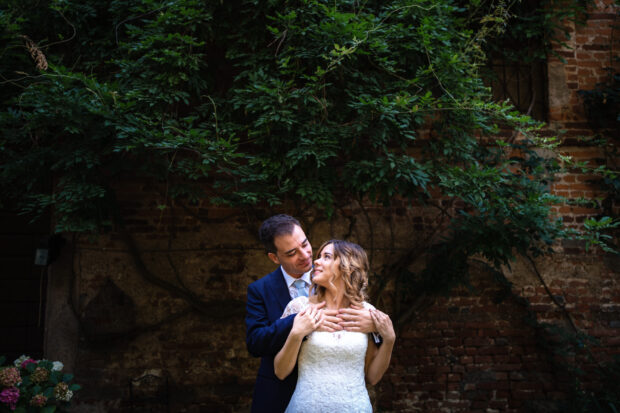Gli sposi posano tra le fronde di glicine al Castelletto di Corbetta.