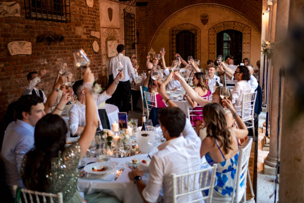 Vista panoramica del chiostro del Castelletto di Corbetta allestito per il pranzo con gli invitati che alzano i calici.