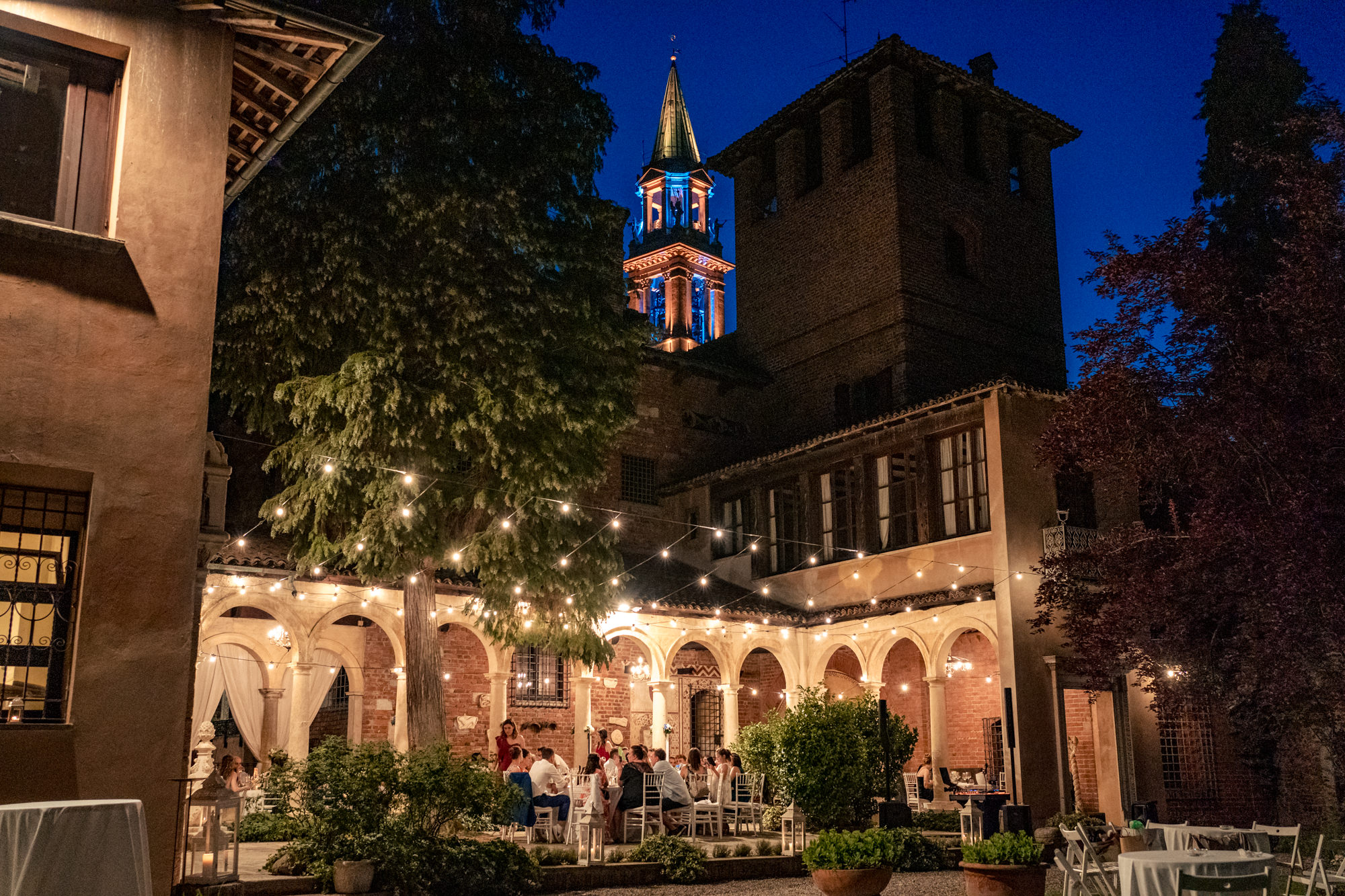 Vista notturna del cortile del Castelletto di Corbetta illuminato da filari di lucine.