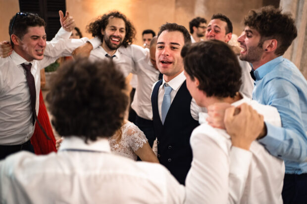 Lo sposo balla con gli amici, tra risate e momenti di puro divertimento.