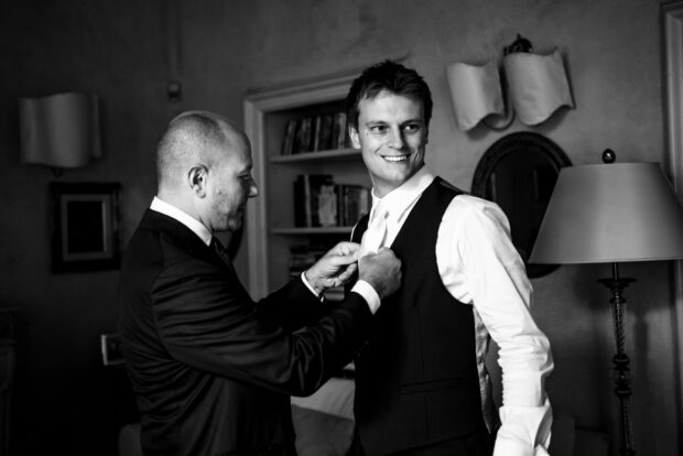 Il testimone aiuta lo sposo ad allacciare il panciotto prima del matrimonio Borgo della Rocca.